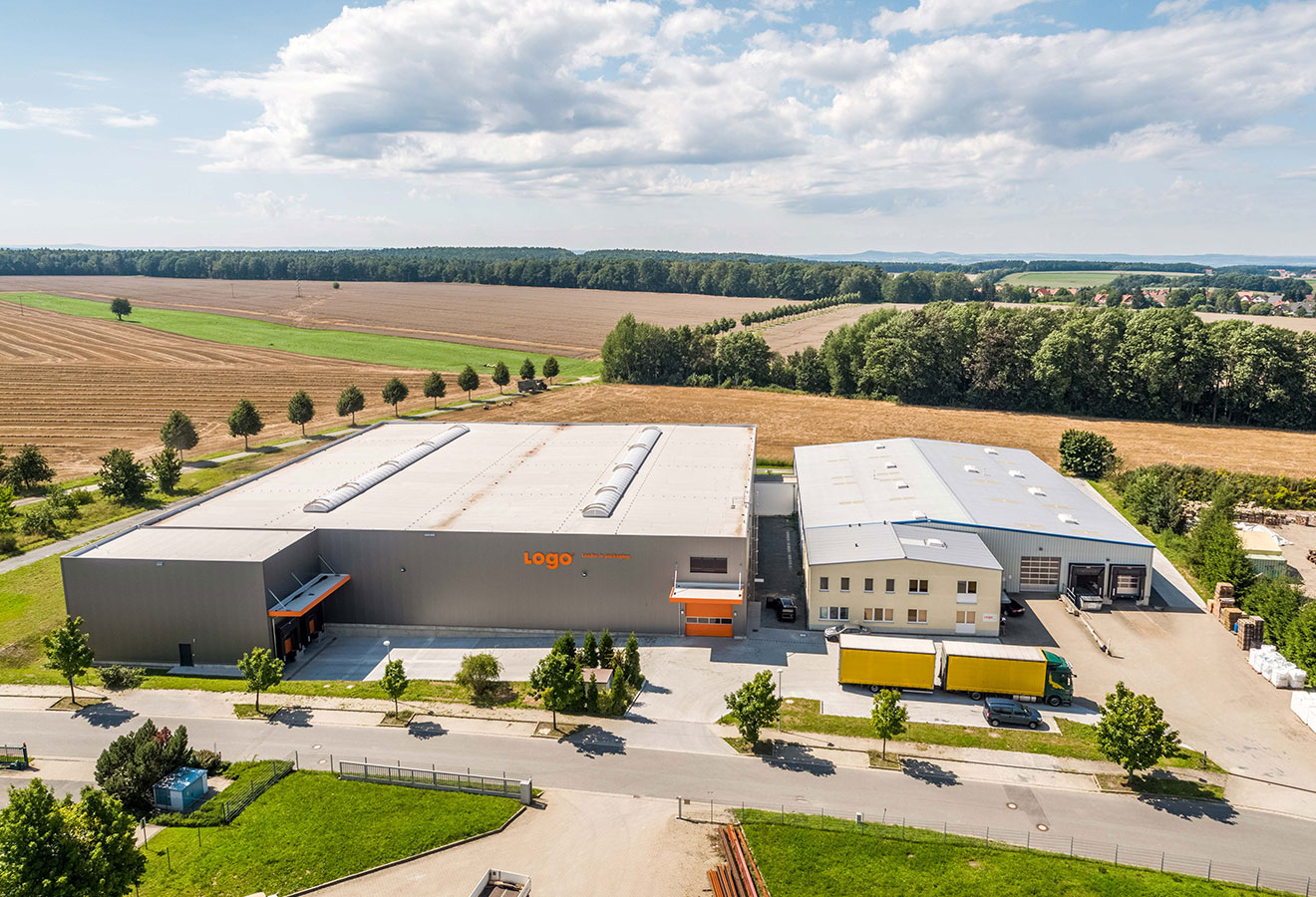 Veduta aerea dello stabilimento Logo-Plastic con capannone di produzione, area di carico e autocarri